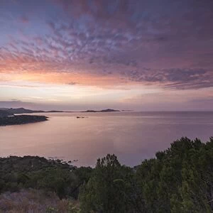 The colors of sunrise are reflected on the sea around the beach of Solanas, Villasimius