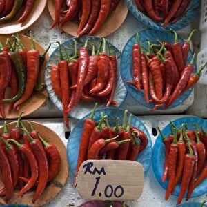 Colourful red chillies on blue plates on a market stall in Kuching, Sarawak
