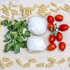 Composition with the bright colours of Italian food: pasta, spaghetti, tomatoes from Sicily, mozzarella from Naples and basil, Italy, Europe