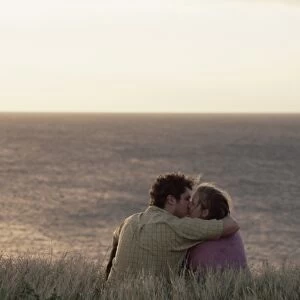 Couple kissing on cliff overlooking Pacific Ocean at South Point