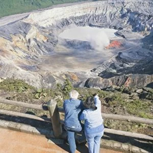 Couple looking at Poas Volcano, Poas Volcano National Park, Costa Rica, Central America