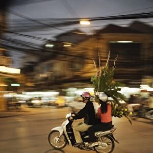 Couple on moped carrying floral display, Hanoi, Vietnam, Indochina, Southeast Asia, Asia