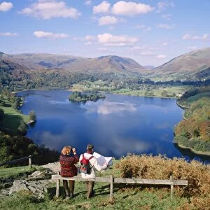 Couple resting on bench, viewing the lake at Grasmere, Lake District, Cumbria
