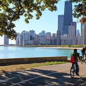 Cyclists riding along Lake Michigan shore with the Chicago skyline beyond, Chicago, Illinois, United States of America, North America