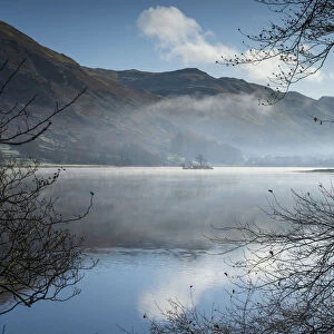 Dawn light and transient sunlit mist over Wall Holm Island on Ullswater, Lake District