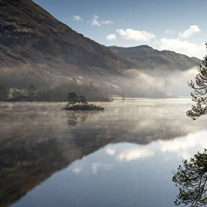 Dawn light and transient sunlit mist over Wall Holm Island on Ullswater, Lake District