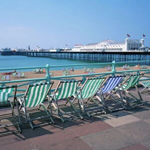 Deckchairs above the beach and the Palace Pier at Brighton, Sussex, England