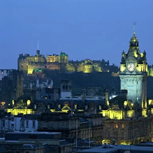Edinburgh Castle and the Waverley Hotel clock tower illuminated at dusk