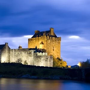 Eilean Donan Castle floodlit against deep blue twilight sky and water of Loch Duich