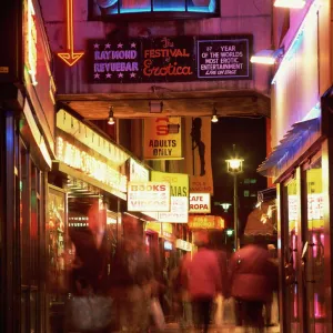 Exterior of sex shops and signs in red light area at night, Soho, London