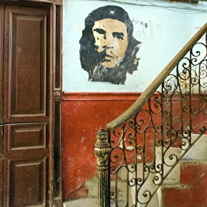Faded mural of Che Guevara on the staircase of a dilapidated apartment building