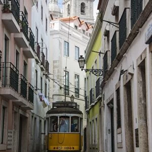 Famous tram 28 going through the old quarter of Alfama, Lisbon, Portugal, Europe