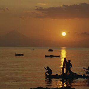 Fishermen silhouetted at sunset at Ende on the island of Flores