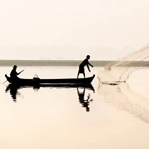 Fishermen on Taungthaman Lake in dawn mist, casting net near U Bein Bridge, Amarapura, near Mandalay, Myanmar (Burma), Asia