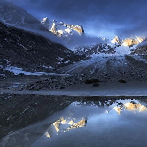 Forno Glacier reflected in a pond at foggy sunrise, Forno Valley, Maloja Pass, Engadine