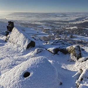 Fresh snow on millstone, Curbar Edge, misty Derwent Valley with Curbar and Baslow villages, Peak District, Derbyshire, England, United Kingdom, Europe