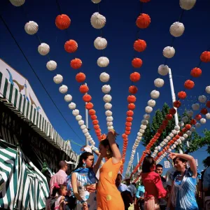 Girls dancing a sevillana beneath colourful lanterns