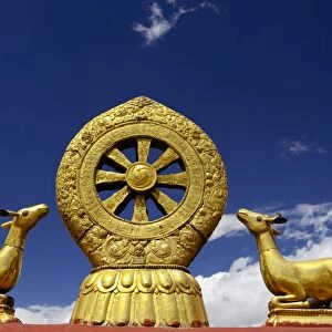 A golden dharma wheel and deer sculptures on the sacred Jokhang Temple roof, Barkhor Square, Lhasa, Tibet, China