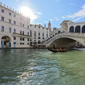A gondolier rowing under Rialto Bridge in Venice, UNESCO World Heritage Site, Veneto