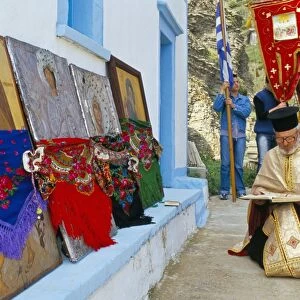 Greek Orthodox priest praying during Lambri Triti festival