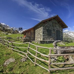 Green meadows and mountain hut on a summer sunny day, Orobie Alps, Arigna Valley