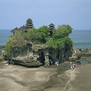 A group of tourists visit the Tanalot Temple on the island of Bali