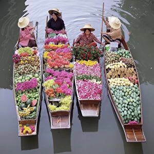 A group of four women market traders in boats laden