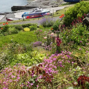 Harbour with boats and village centre, garden and flowers, blue sky on a sunny summer day