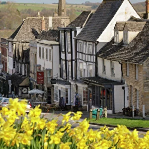 High Street and Burford Church with daffodils, Burford, Cotswolds, Oxfordshire, England