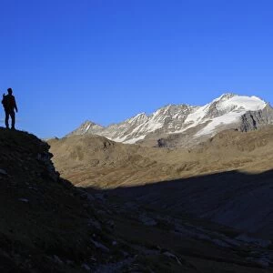 Hiker admires the view of Alpi Graie (Graian Alps) landscape, Gran Paradiso National Park