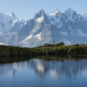 Hikers reflected in Lake Cheserys, Mont Blanc, French Alps, France, Europe