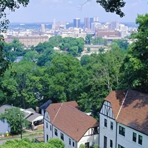 Houses amid trees and city skyline in the background