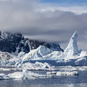 Huge iceberg amongst sea ice in the Yalour Islands, western side of the Antarctic Peninsula, Southern Ocean, Polar Regions