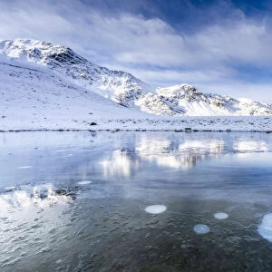 Ice bubbles on the icy surface of an alpine lake, Stelvio Pass, Valtellina, Lombardy