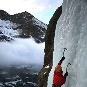 An ice climber makes his way up a frozen waterfall near Cogne, above the Aosta Valley