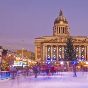 Ice skaters on the temporary Christmas outdoor ice skating rink in the Old Market Square in front of the Council House in the city centre, Nottingham, Nottinghamshire, England, United