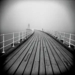 Image taken with a Holga medium format 120 film toy camera looking along timber boardwalk of Whitby pier on misty winters day, Whitby, North Yorkshire, England, United