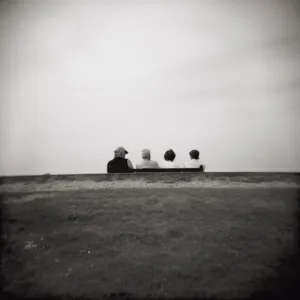 Image taken with a Holga medium format 120 film toy camera of four people on a bench overlooking the sea, Freshwater Bay, Isle of Wight, Hampshire, England, United Image taken with a Holga medium format 120 film toy camera of four people on a bench overlooking the sea, Freshwater Bay, Isle of Wight, Hampshire, England, United