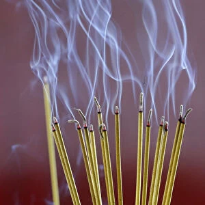 Incense sticks on joss stick pot burning, smoke used to pay respect to the Buddha