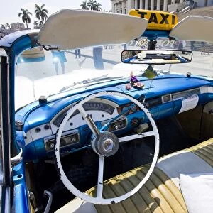 Interior of old American car being used as a taxi showing blue dashboard