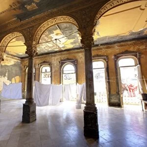 Interior of a once ornate and grand apartment building, now in a state of disrepair