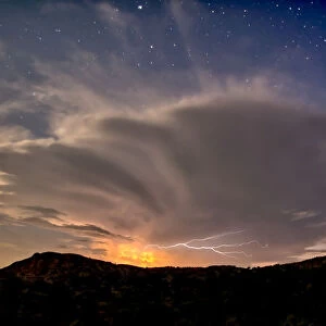 An isolated storm cell near Chino Valley being lit by the Moonlight during the summer