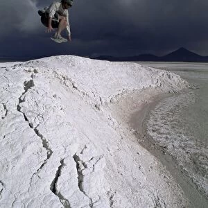 Jumping above the borax deposits on borders of Laguna Colorado, Bolivia, South America