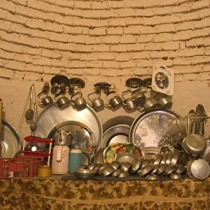Kitchen ware inside beehive house built of brick and mud