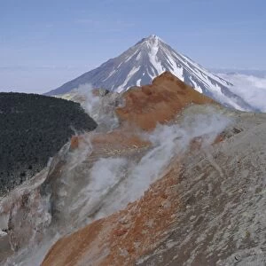 Koryaksky volcano seen beyond walkers on crater rim of Avacha volcano