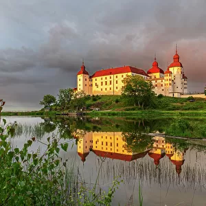 Lacko Castle and the reflection in the water at sunset, Kallandso island, Vanern lake, Vastra Gotaland, Sweden, Scandinavia, Europe