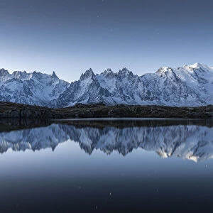 Lacs des Cheserys lake and peaks of Mont Blanc massif covered with snow at night