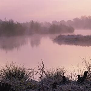 Lake on a frosty autumn morning with mist rising from Colebrook Lake South in Moor Green Lakes Nature Reserve, Finchamstead, Berkshire, England, United