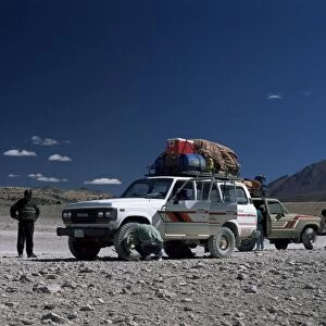 Landcruisers and tourists on jeep tour taking a break on Uyuni salt flat