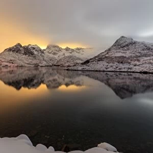 The light of the moon and snowy peaks reflected in the cold sea lit the night at Svolvaer